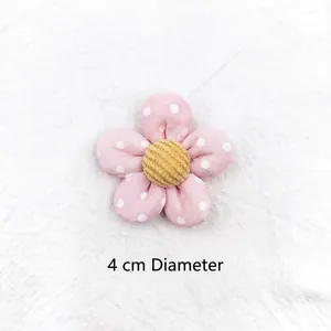 Close-up of pink polka dot fabric flower with yellow corduroy center 4cm diameter