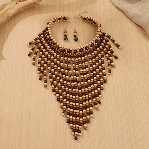 Makro-Detail einer böhmischen Holzperlenkette mit Fransen auf Holz Hintergrund