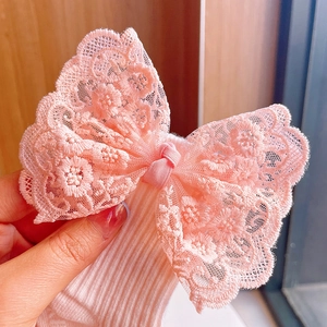 Close-up of pink lace bow accessory for baby headband made of soft ribbed cotton fabric