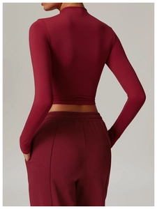 Detail of the high-neck cropped yoga top and high-waist leggings in deep red matte fabric