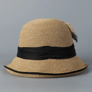 Detailed close-up of woven straw texture and black fabric ribbon on a sun hat