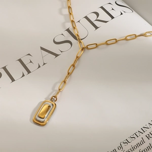 Minimalistische gold-silberne geometrische Halskette auf einem Zeitschriftenhintergrund