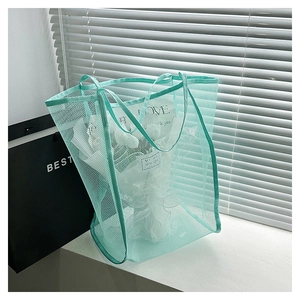Dettaglio borsa shopper in rete verde chiaro con manici rinforzati in stile moderno