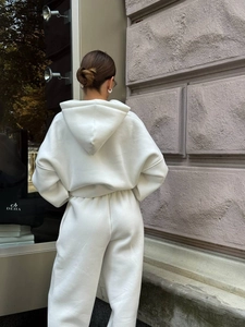 Detail view of the back silhouette and premium cotton fabric of ivory hooded tracksuit