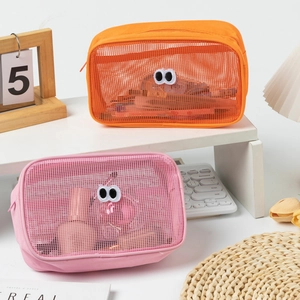 Detail of orange and pink mesh cosmetic bags with cute big eye embroidery and zipper