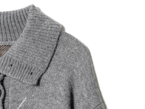 Dettaglio del cardigan in maglia grigia con colletto a coste e bottoni scuri