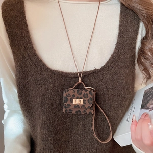 Detail of leopard print mini necklace bag with gold clasp and brown leather texture