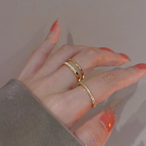 Close-up of gold-plated double-layer open ring and thin zircon band worn on fingers