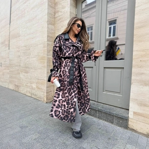 Dettaglio del trench leopardato con risvolto in pelle nera e cintura in vita