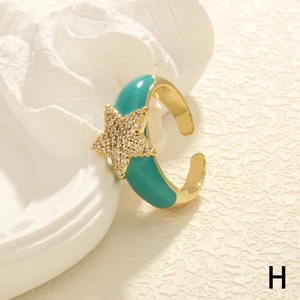 Detail of star-shaped zircon ring with cyan enamel finish and adjustable gold band
