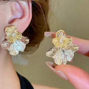 Elegante gold- und silberne Lagenohrstecker in Blumenform mit glitzernden Kristallen