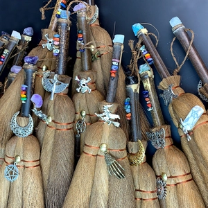 Handmade brown witch broom featuring natural crystals and skull pendants for DIY decor