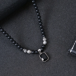 Detail of matte black beads and tiger eye stones with a black gemstone pendant necklace