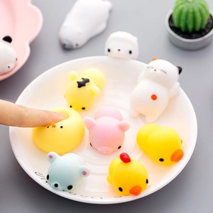 Detailed macro view of soft animal-shaped mochi squishy toys being squeezed in a white bowl.