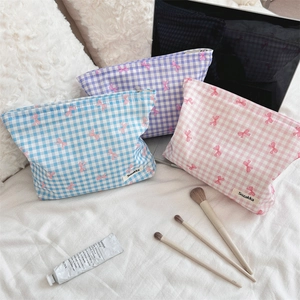 Detailed view of three floral checkered toiletry bags in blue, purple and pink cotton