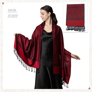 Close-up of luxury burgundy paisley jacquard shawl scarf featuring black fringe tassels