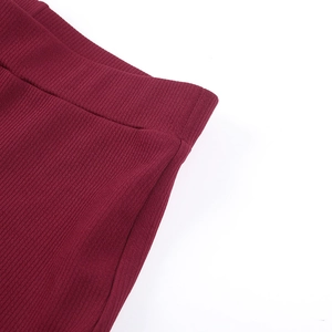 Dettaglio macro della trama in maglia a coste bordeaux e della fascia elastica in vita