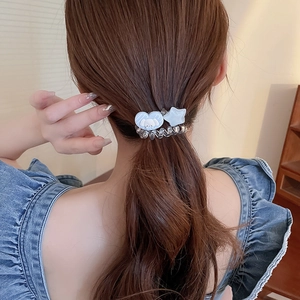 Détail d'un élastique à cheveux en fil de téléphone argenté avec breloques Cinnamoroll