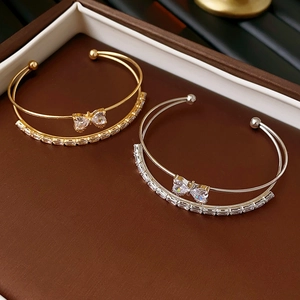 Close-up of bow knot double layer zircon bracelets in gold and silver finish