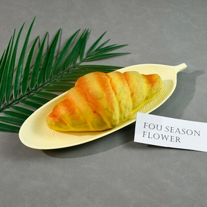 Modèle de croissant réaliste sur plateau de feuilles pour présentoirs de cuisine