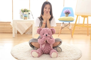 Detail of pink rose swirl plush teddy bear with silk bow and shy sitting pose