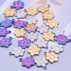 Macro view of five-petal flower charms in gold, silver, and iridescent finishes for DIY