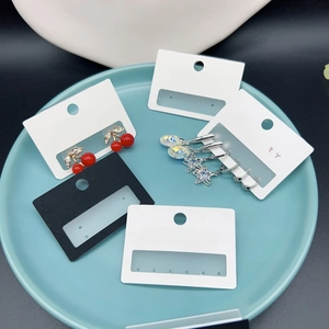Macro detail of cherry and star earrings displayed on jewelry presentation cards