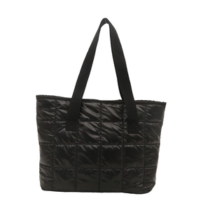 Minimalist large black quilted tote bag with wide webbing handles and sleek finish