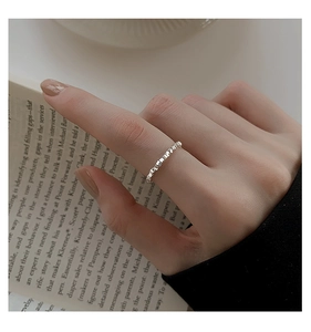 Close-up of a silver geometric textured ring worn on finger with minimalist design