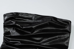 Gros plan sur le cuir PU noir montrant les coutures fines et la texture plissée naturelle