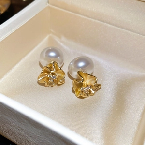 Detailed close-up of 18k gold plated flower earrings with pearls and zircons in a gift box