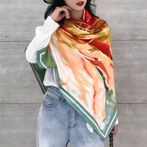 Detail view of a 130cm silk floral scarf with vibrant orange and green oil painting patterns