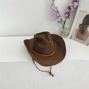 Detail of dark brown woven straw cowboy hat with breathable mesh and adjustable chin strap