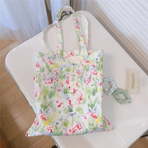Detail of floral canvas tote bag with watercolor patterns and decorative hair accessories