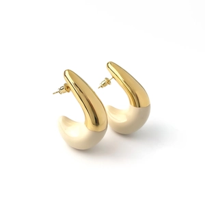 Close-up of C-shaped hoop earrings featuring 18K gold plating and cream enamel splicing