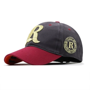 Detailed side view of baseball cap featuring circular embroidery and gold letter stitching