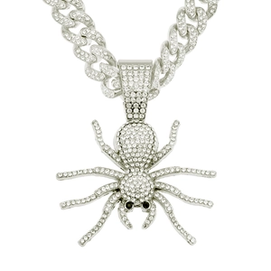 Close-up of silver-tone spider pendant with crystals on Cuban link chain