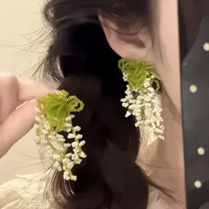 Handcrafted lily of the valley earrings with green leaves and white crystal beads