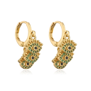 Detail von goldenen Evil-Eye-Ohrringen mit mikro-pavé grünen und schwarzen Kristallen