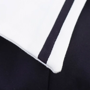 Detail of white mini dress neckline featuring premium twill fabric and blue striped trim