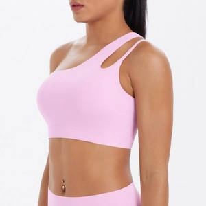 Detail of light pink one-shoulder sports bra featuring asymmetric cut-out straps