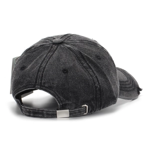 Detail view of the metal adjustable buckle on a vintage black washed denim baseball cap