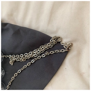 Detailed macro view of silver metal chain links and transparent acrylic beads on bag strap