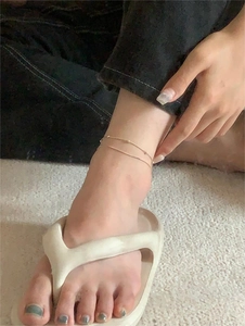Detailed view of a gold double-layer snake chain anklet with delicate bead accents