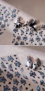 Vista macro di adesivi laser per unghie a farfalla con finitura olografica su French tips