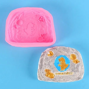 Détail du moule en silicone dinosaure avec roche en argile grise et fossiles dorés