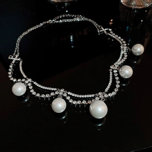 Macro shot of double-layered pearl necklace with silver rhinestones on black background