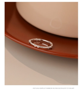 Close-up of a s925 silver bow ring with mirror polished finish on dark wood surface