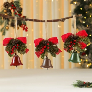 Three-piece Christmas metal bells with pine cones and burlap bows hanging on a branch