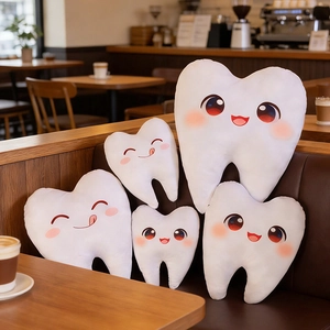 Lot de 5 coussins dents en peluche avec expressions mignonnes sur un canapé